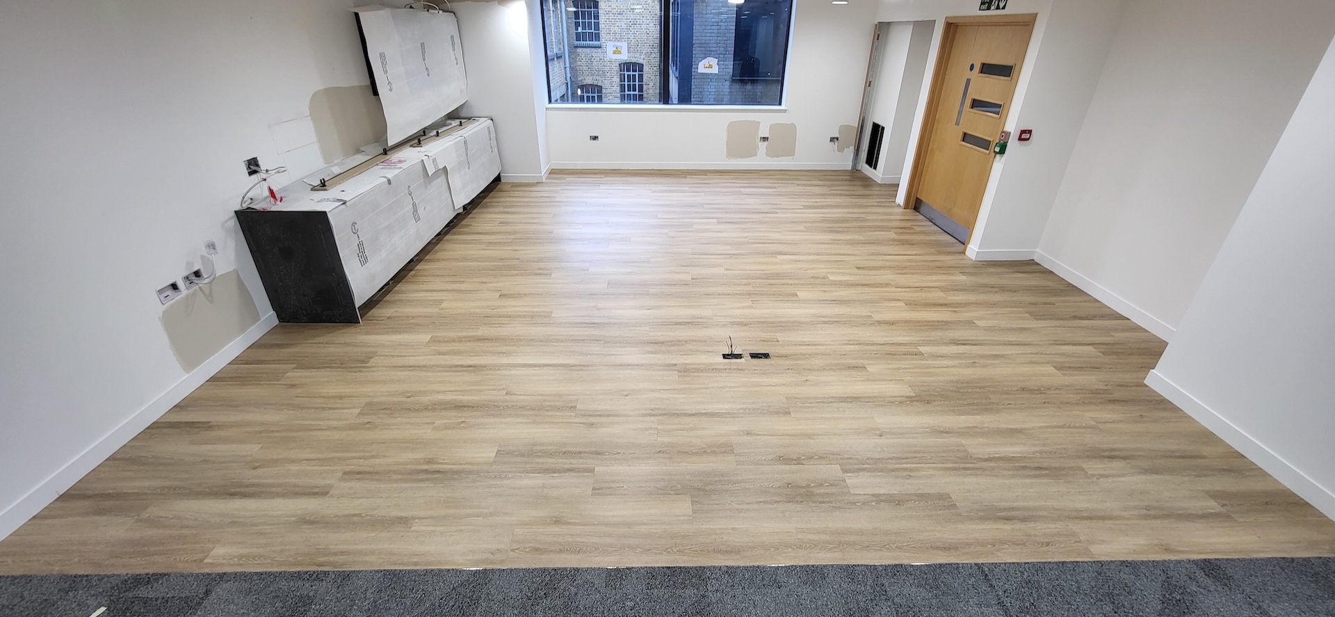 We were invited to work on this project with Main Contractors AIS, near to Blackfriars Bridge. The installation included Paver carpet tiles (with an 84% recycled content), Terazzo vinyl tiles, which have an attractive stone-effect embossing, and Spacia wood-effect LVT.

The areas for LVT installation required careful preparation. Firstly, the existing concrete subfloor was thoroughly cleaned, after which our team applied a specialist smoothing compound to achieve a fine surface for ready for the LVT planks to be installed through the corridor and refreshment points - and to achieve the best transition between the carpet and LVT.

Finally, a new entrance matwell was installed to prevent the ingress of dirt and keep the floors looking pristine.